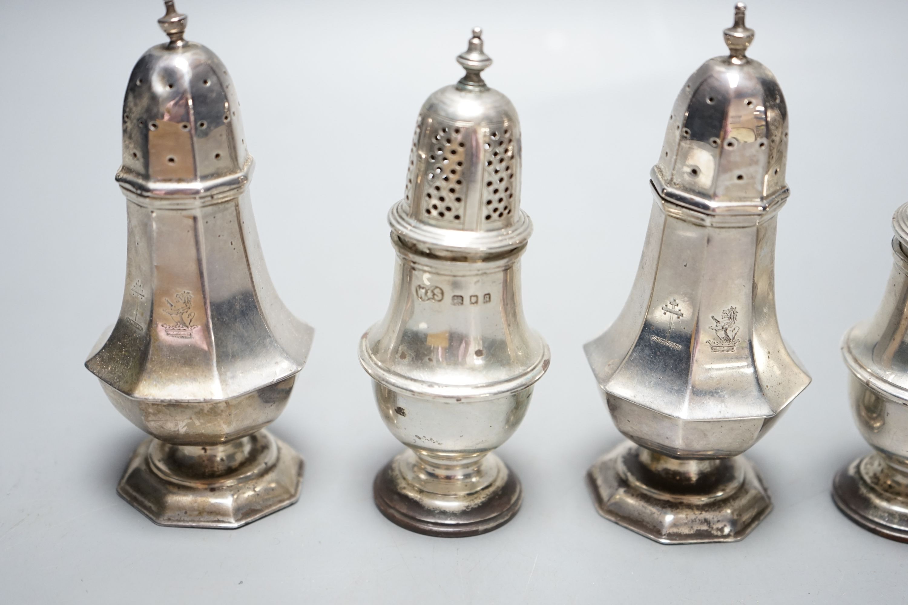 A pair of late Victorian silver panelled pepperettes, London, 1900 and a later pair, London, 1931, 232 grams.